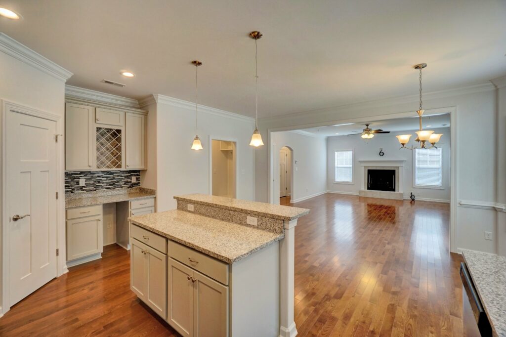 Home Builder in Smithfield VA. The Augusta Island, Wine Storage, Eat-in Kitchen, Living Room, and Fireplace View from Kitchen