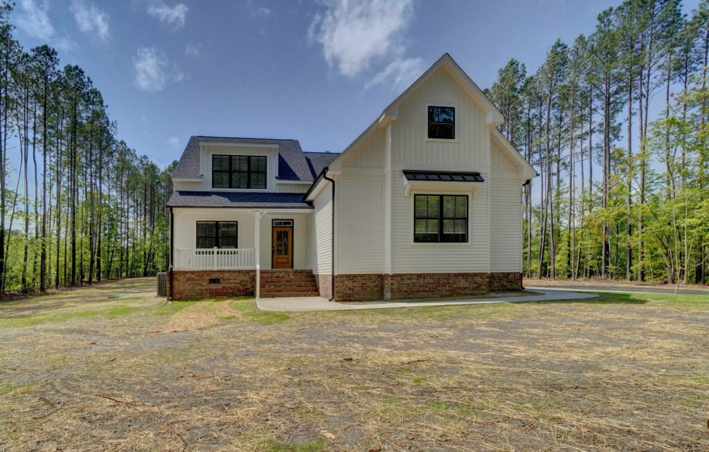 Home Builder in Surry VA. The Grayson Exterior Front White with Black Windows, Sidewalk, and Porch No Grass