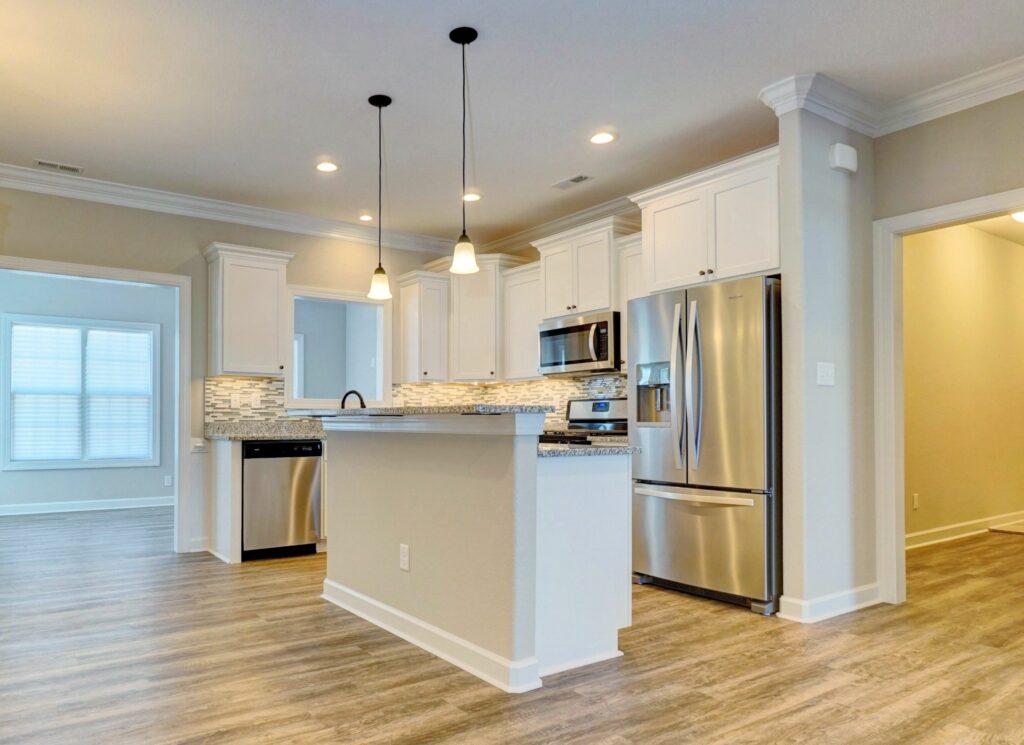 The Springfield II Open with Kitchen, Island Lighting, and Entrance to Laundry Room